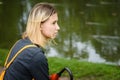 Young girl sitting on the grass in the Park by the lake with a red umbrella Royalty Free Stock Photo