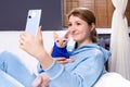 A young girl sitting at home on the couch makes a selfie with a bald cat. Sphinx with blue eyes looks into the camera of the phone Royalty Free Stock Photo