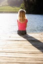 Young girl sitting by lake Royalty Free Stock Photo