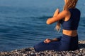 Young girl sitting in Lotus pose on the beach at sunset Royalty Free Stock Photo