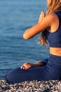 Young girl sitting in Lotus pose on the beach at sunset Royalty Free Stock Photo