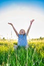 A young girl sitting in a meadow, loving the sunshine and freedom of being out of the house. Royalty Free Stock Photo