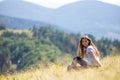 Young girl is sitting on the mountainside