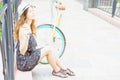 Young girl sitting near vintage bike at park Royalty Free Stock Photo