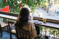 Young girl sitting in the open cafe with Hanoi street on background in Hanoi city, Vietnam