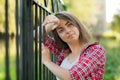 A young girl is sitting outdoors on the grass in a tree, brooding look, a summer day outdoors in the Park