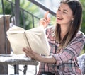 girl sitting outside in a plaid shirt and reading a book Royalty Free Stock Photo