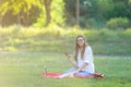 Young girl sitting in the park, smiling and working at his laptop, listening to music Royalty Free Stock Photo