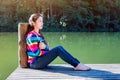 Young girl sitting on a pier. Royalty Free Stock Photo