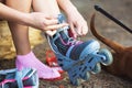 Young girl sitting and putting on inline skates Royalty Free Stock Photo