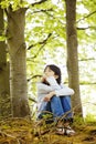 Young girl sitting quietly in woods