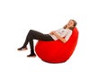 Young girl sitting on red beanbag chair Royalty Free Stock Photo