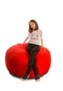 Young girl sitting on round shape red beanbag chair