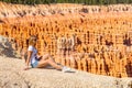 Young girl sitting by the scenic view of stunning red sandstone hoodoos