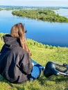 Young girl sitting on the shore of the lake, summer and sports