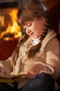 Young Girl Sitting On Sofa Reading A Book Royalty Free Stock Photo