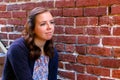 Girl Sitting on Stairway, Next to Red Brick Wall Royalty Free Stock Photo