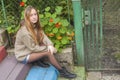 Young girl sitting on the steps near the country house.