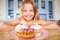 Young Girl Sitting At Table Looking At Plate Of Sugary Cakes Royalty Free Stock Photo