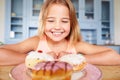 Young Girl Sitting At Table Looking At Plate Of Sugary Cakes Royalty Free Stock Photo