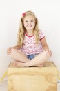 Young Girl Sitting On Wooden Toy Box Reading Book In Bedroom Royalty Free Stock Photo