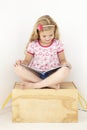 Young Girl Sitting On Wooden Toy Box Reading Book In Bedroom Royalty Free Stock Photo