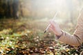 A young girl sketching near a lake in the autumn forest. Sketching. The girl is in a great mood and happy