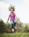 Young girl skipping in park Royalty Free Stock Photo