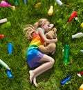 Young girl sleeping with her teddy bear in the plastic littered Royalty Free Stock Photo