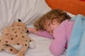 Cute little girl sleeping tired or sick in a bed Royalty Free Stock Photo