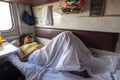 A young girl sleeps on a lower bunk in a reserved seat of a train car Royalty Free Stock Photo