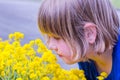Young girl smelling yellow flowers