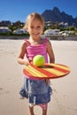 Young girl, smile and tennis ball in beach with bat, playing and active outdoor. Child, motor skills and growth for Royalty Free Stock Photo