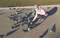 A young girl smiles and feeds a flock of gray pigeons on the street Royalty Free Stock Photo