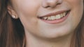 A young girl smiles and shows her crooked teeth.