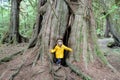 A young girl smiling as she stands inside a giant spruce tree