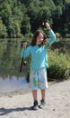 Young girl smiling at her first fish caught while fishing from a small pond