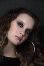 Young girl with smoky eye makeup and fancy ring earrings, selective focus, grainy