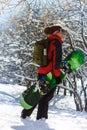 Girl with snowboard in the winter forest