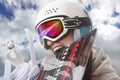 Young girl snowboarder in helmet and goggles bites snowboard Royalty Free Stock Photo