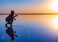 A girl splashes to the side on a transparent surface on an fiery evening