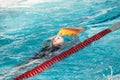 Young girl sportsman swiming backstroke with kickboard in pool Royalty Free Stock Photo