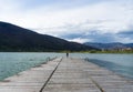 A young girl standing alone in the center of the frame looking out towards the seat. Peaceful and beautiful landscape. A long Royalty Free Stock Photo