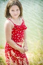 A young girl in a dress stands on the bank of a cliff Royalty Free Stock Photo