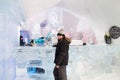 Young girl standing at the bar of the world-renowned seasonal Ice Hotel dressed in warm winter clothes Royalty Free Stock Photo