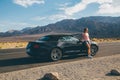 Young girl standing by the black Ford Mustang GT