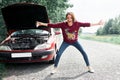 Young girl standing at the broken car and looking for help Royalty Free Stock Photo