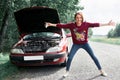 Young girl standing at the broken car and looking for help Royalty Free Stock Photo