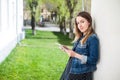 Young girl standing on the college campus yard with the tablet Royalty Free Stock Photo