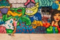 Young girl standing by the colorful graffiti wall in Los Angeles